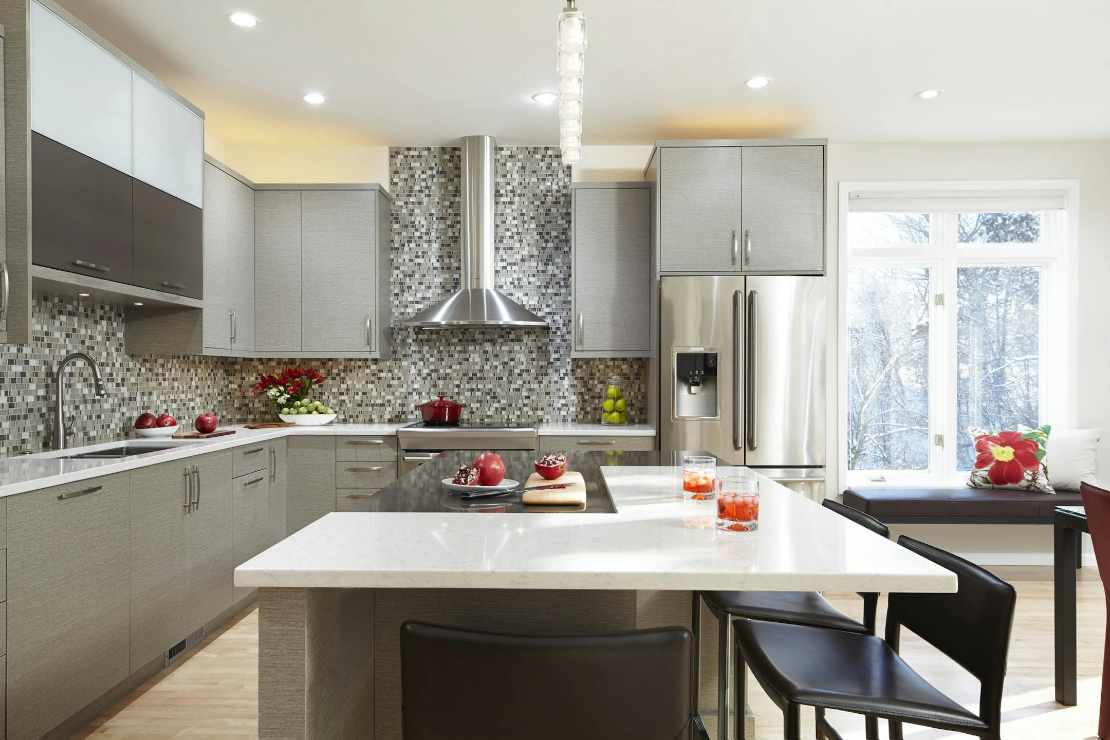 Two L-shaped interlocking quartz tops designate eating and prep spaces on the island.