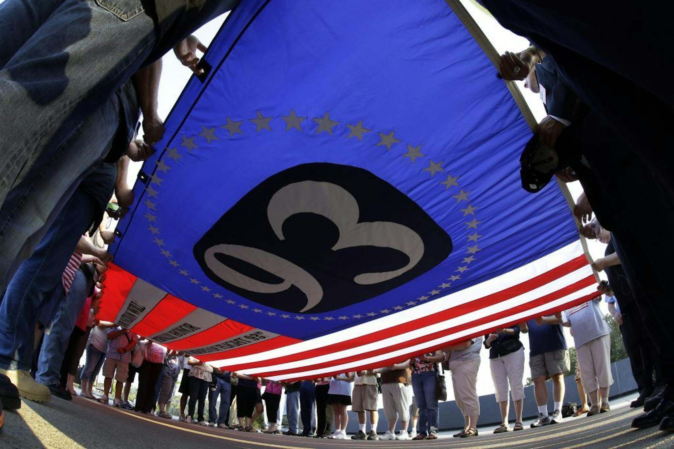 Visitors to the Flight 93 National Memorial participate in a sunset ceremony with a giant flag memorializing Flight 93 on Tuesday, September 10, 2013.