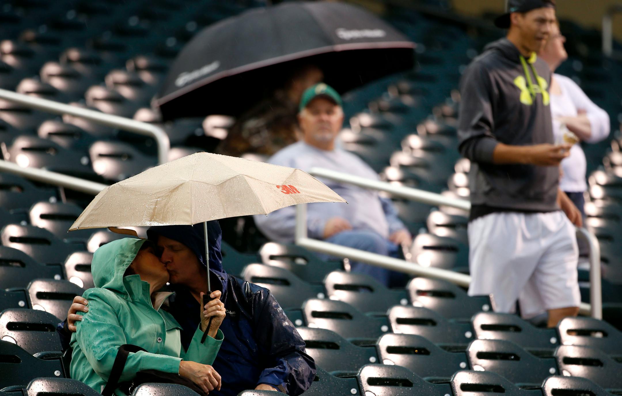 Fans sit in the stands while they wait out the rain delay before the Twins game on Thursday evening.