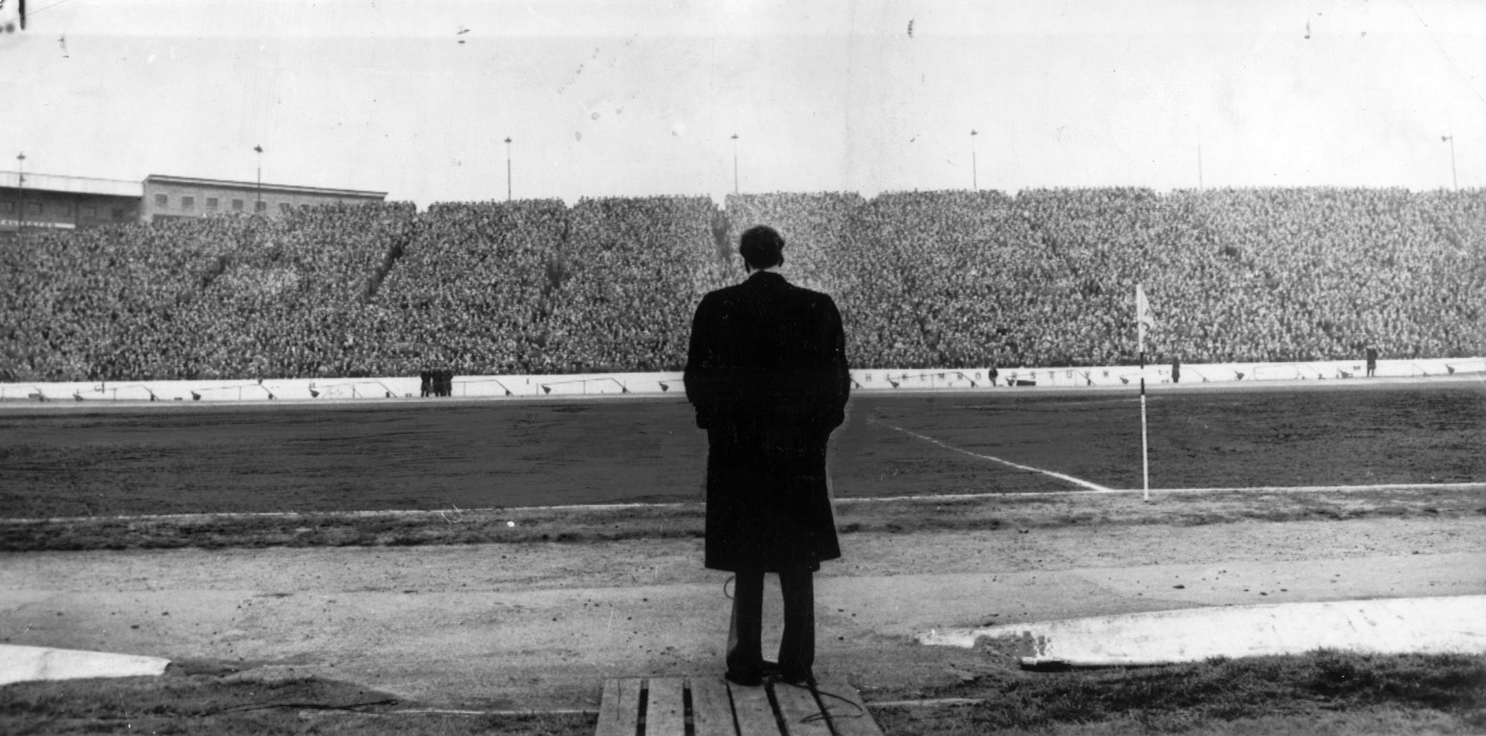 Billy Graham, American evangelist, stood near the playing field at Chelsea, England. Despite thousands of people in the stands, he almost seems alone. He addressed fans attending a game between Chelsea and Newcastle. Photo ran April 27, 1954, Mpls Tribune.