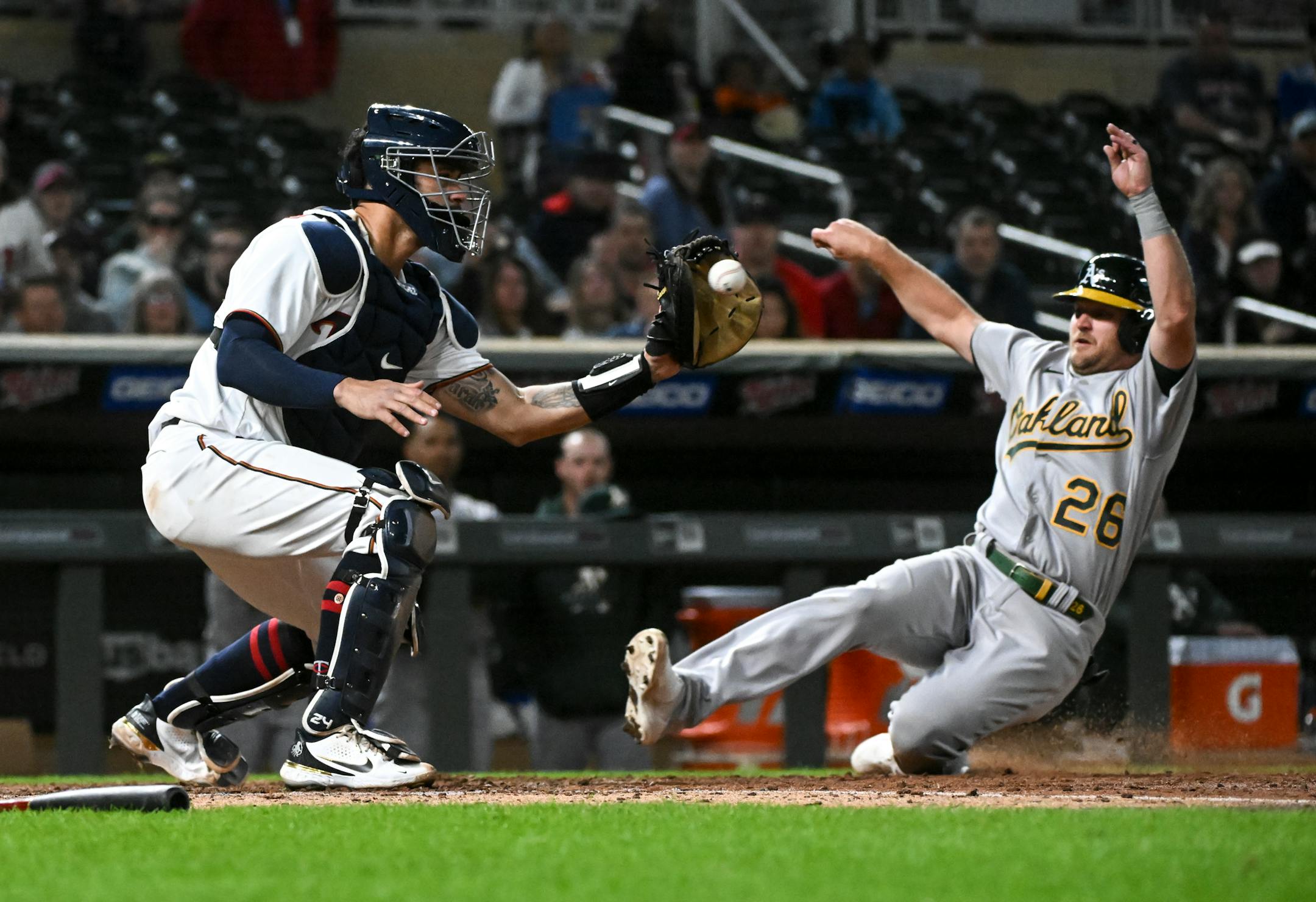 Minnesota Twins catcher Gary Sanchez (24) catches the ball before tagging out Oakland Athletics first baseman Sheldon Neuse (26) in the top of the ninth inning.