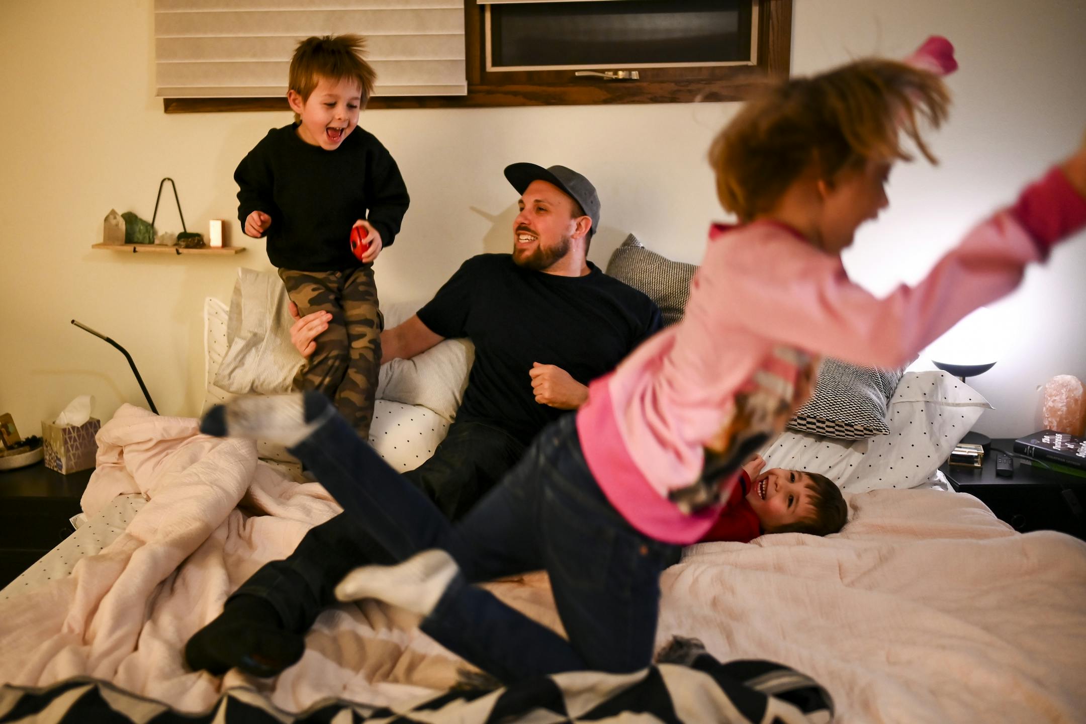 There was a bit of chaos in the bedroom as Aaron Mader played with his three children, twin brothers Lou, left, and Cam, both 4, and daughter Penny, 6.
