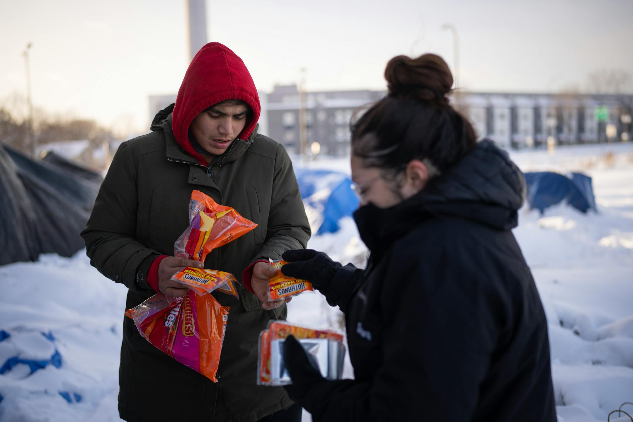 Outreach worker Dava Beaulieu gave hand warmers to a man living in an encampment along Hiawatha Ave. as she and another outreach worker checked on their well being and offered hand warmers and snacks Thursday afternoon. Homeless outreach workers for the American Indian Community Development Corp. (AICDC), checked several homeless encampments to offer hand warmers and snacks or a ride to a shelter on a dangerously cold afternoon in Minneapolis Thursday, December 22, 2022.