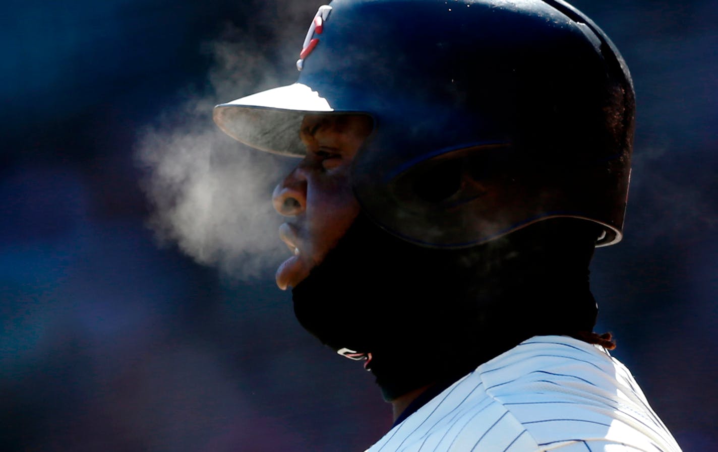 Minnesota Twins' Miguel Sano generates steam as he breathes with the temperatures in the mid-20's while on deck in the first inning of a baseball game against the Seattle Mariners Saturday, April 7, 2018, in Minneapolis.