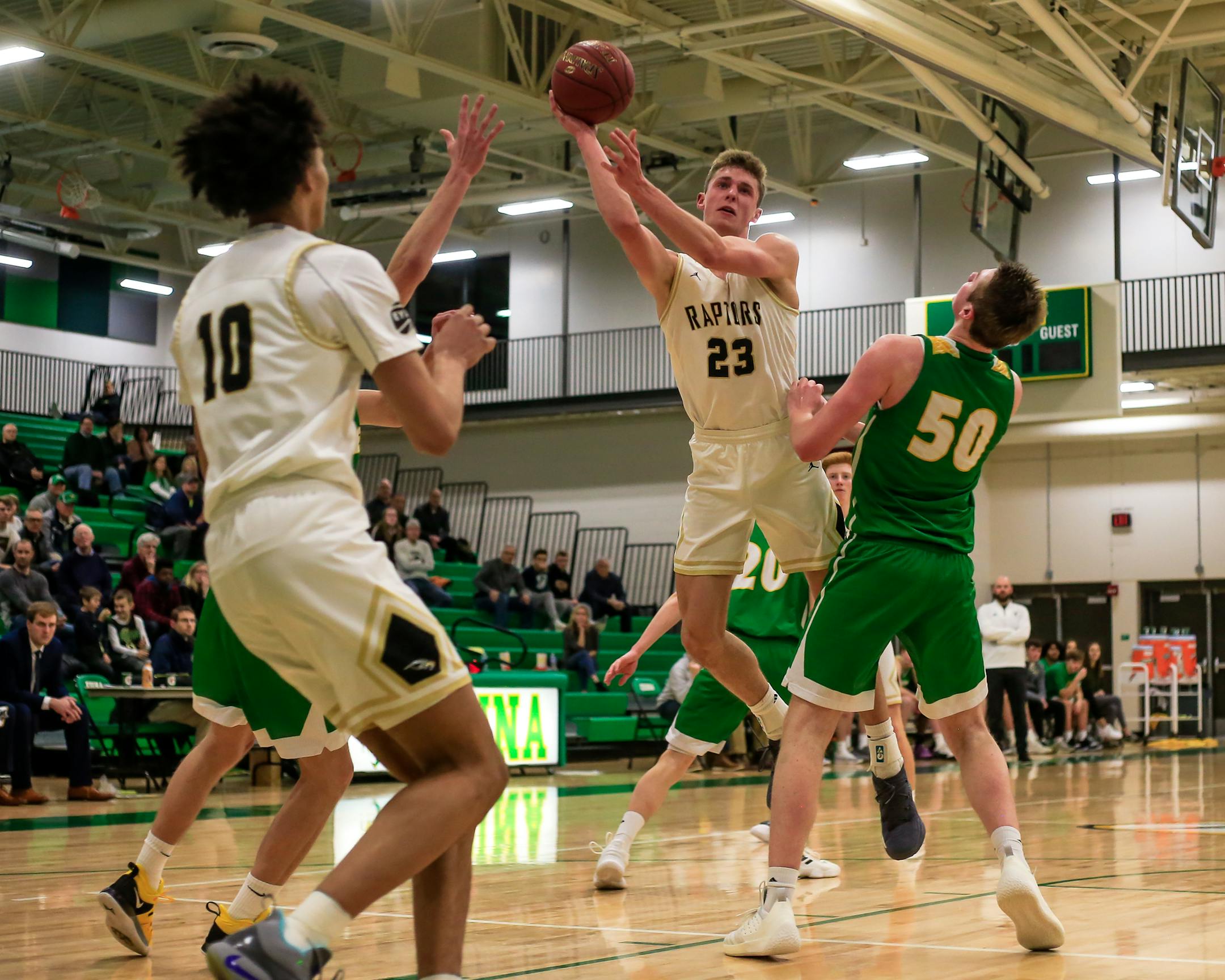 Ben Carlson (23) of East Ridge drives in the lane in a game against Edina on Feb. 21. In the foreground is sophomore teammate Kendall Brown, who also is attracting recruiting looks. Photo by Mark Hvidsten, SportsEngine