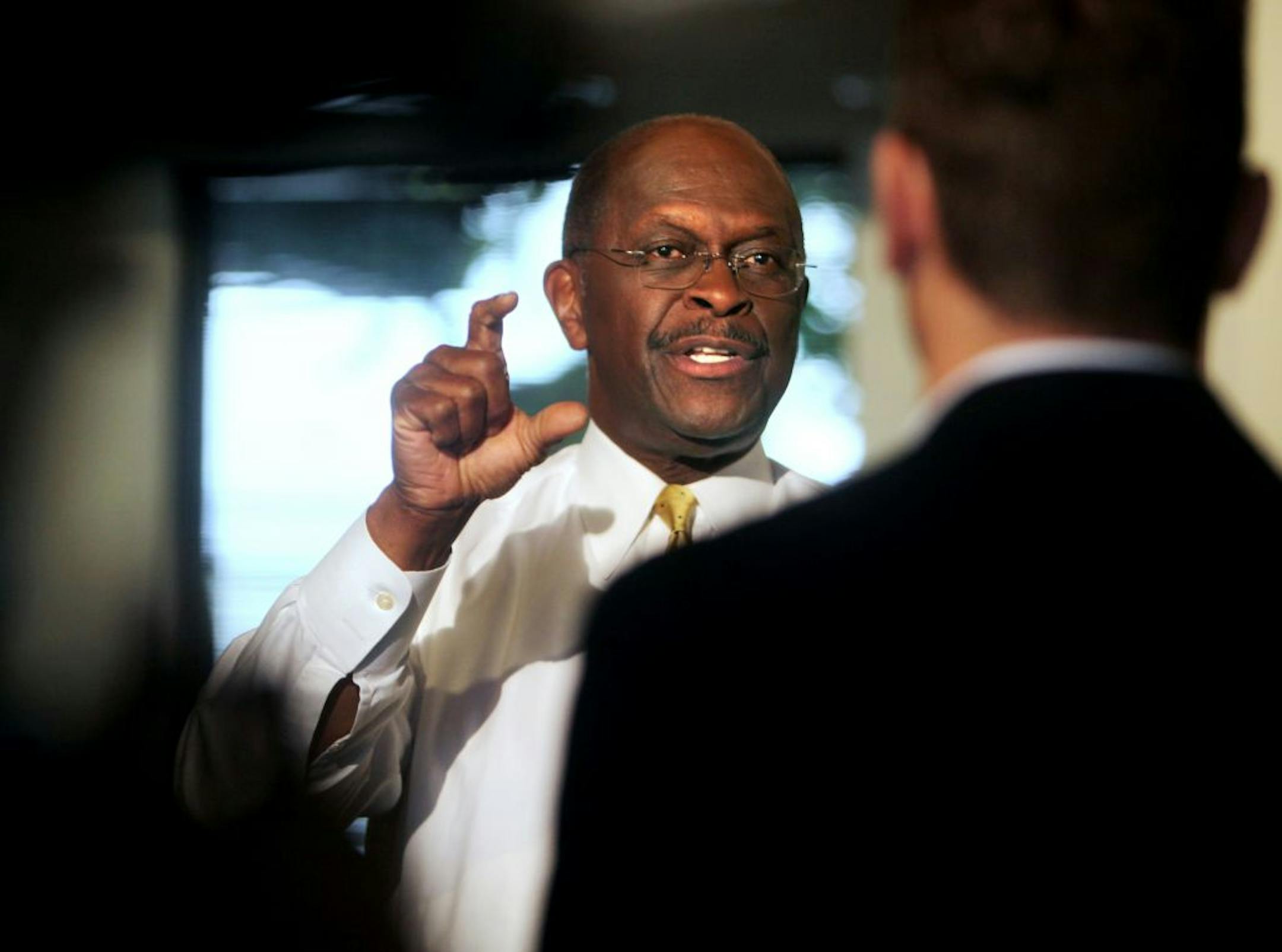 Republican presidential candidate, businessman Herman Cain talks to reporters before heading out of Cincinnati on a private plane at Lunken Airport, Thursday, Oct. 13, 2011.