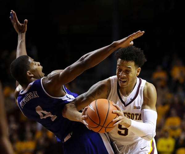 Minnesota guard Amir Coffey (5) drove around Drake guard De'Antae McMurray (4) on his way to the net in the second half.