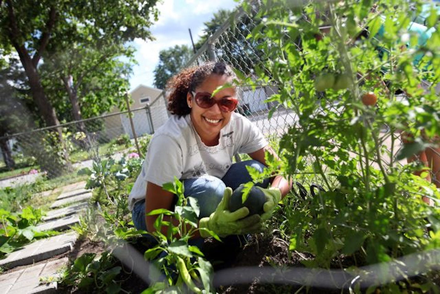 Jamaica DelMar shows off a just-picked watermelon. The novice gardener plans to expand next year.