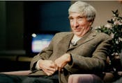 October 10, 1989 John Updike on the set of KTHI-11 news in Fargo, where he was guest on the 5 p.m. news show. He's unhooking the microphone he was wea