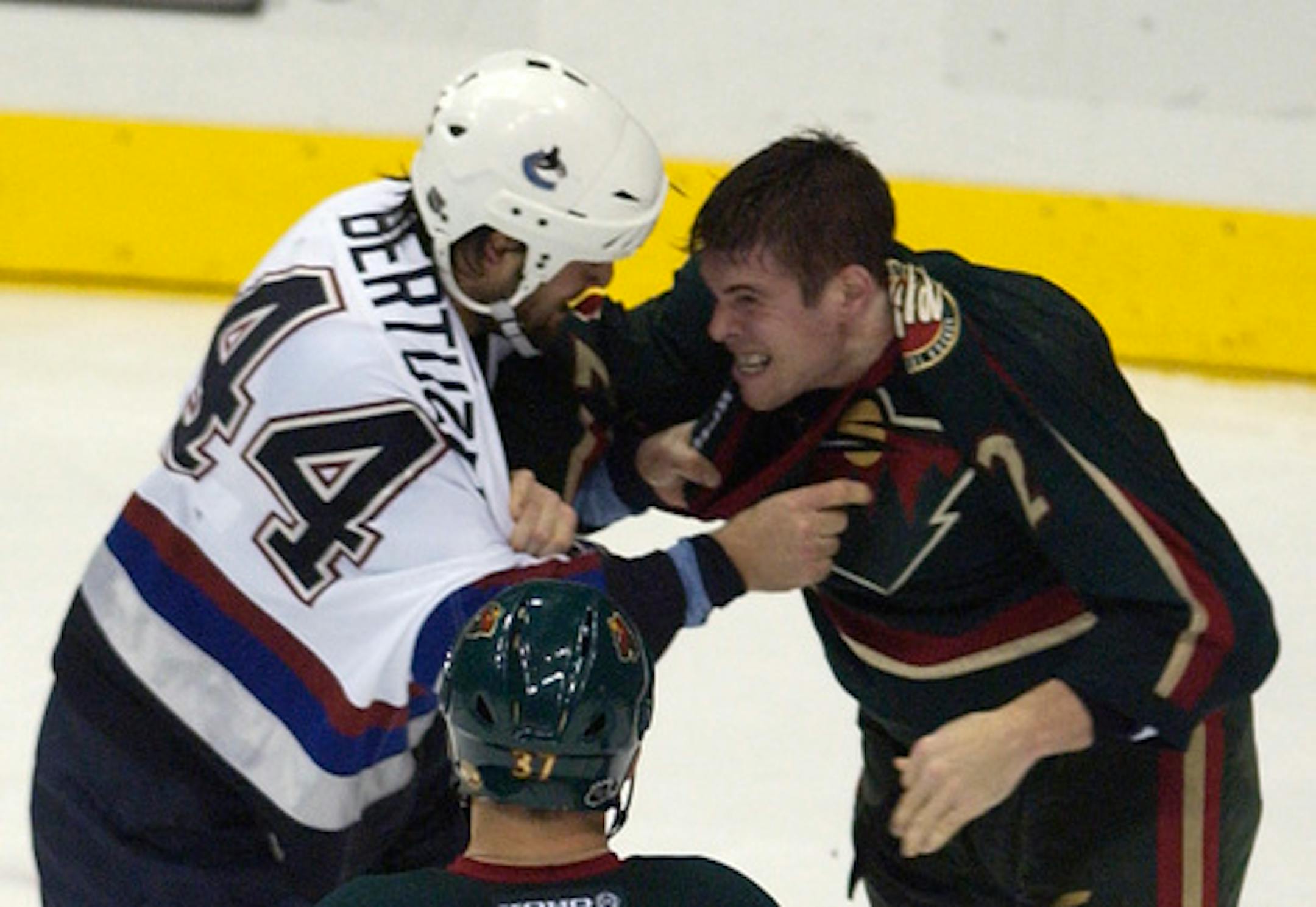 MONDAY_11/11/03_St.Paul - - - - - -  Wild #2 Willie Mitchell takes on Canuck #44 Todd Bertuzzi in the 1st period.