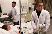 Matthew Girtz, right, and Andrew Hutton worked with instructor Tracy Moshier who was acting as a patient during a simulated situation in the nursing s