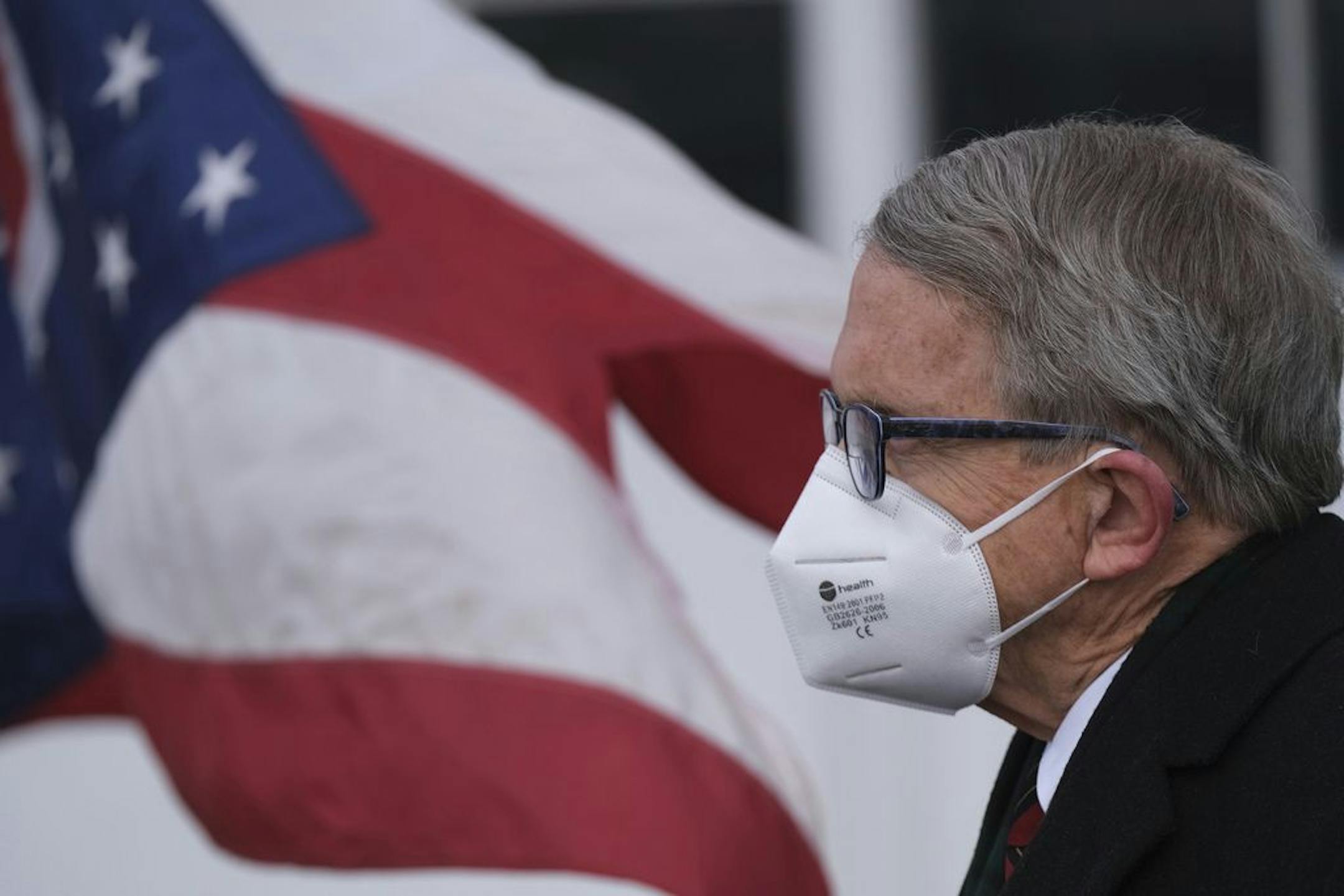 Ohio Gov. Mike DeWine looks on during a press conference Wednesday, Nov. 18, at Toledo Express Airport in Swanton, Ohio. On Tuesday DeWine announced a three-week 10 p.m. to 5 a.m. general curfew, with multiple exceptions, meant to slow the spread of the coronavirus as cases stay at near-record high levels.
