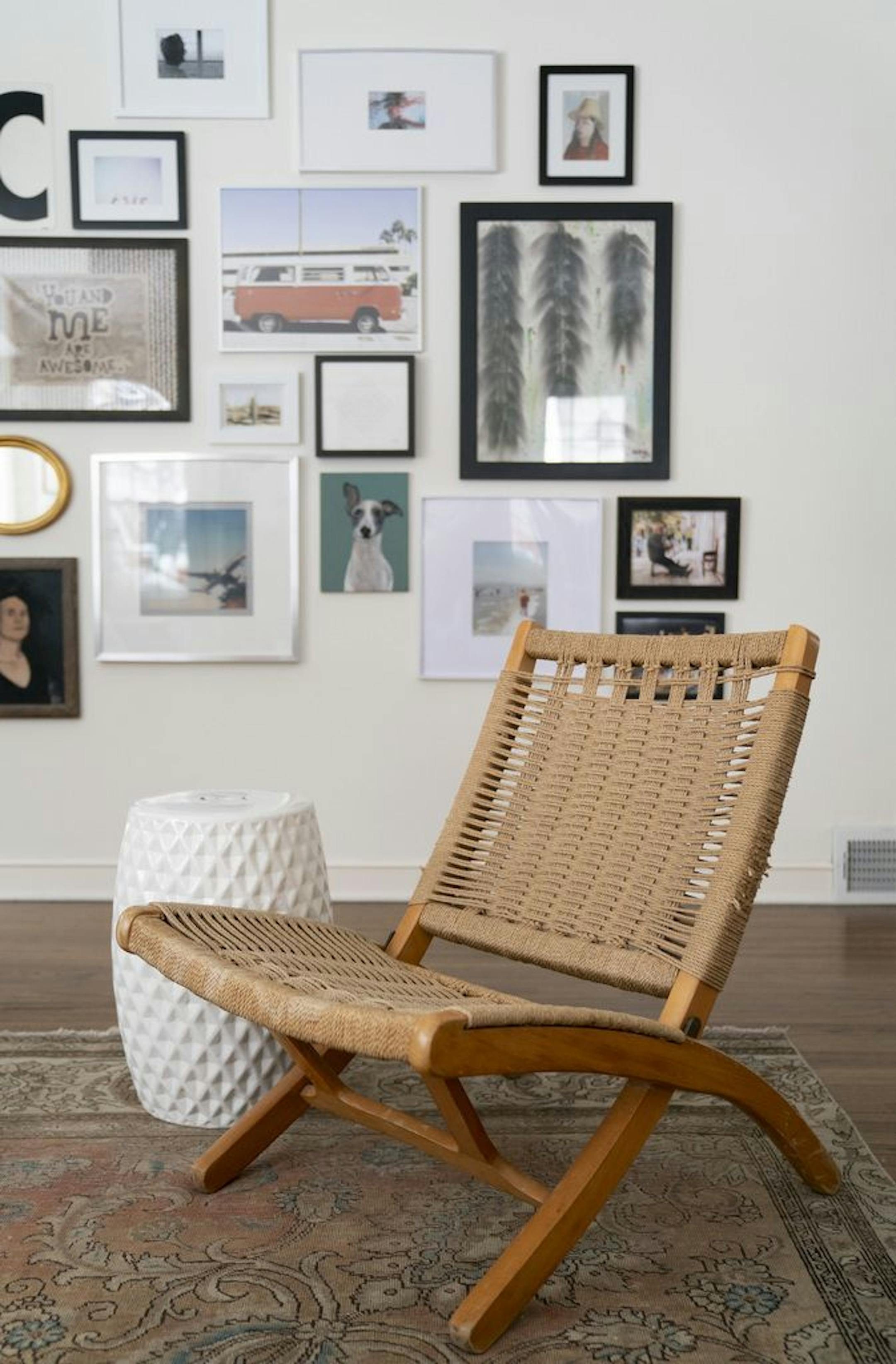 A vintage chair in front of a photo wall.
