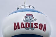 Lou T. Fisk decorates the water tower in Madison, Minn.