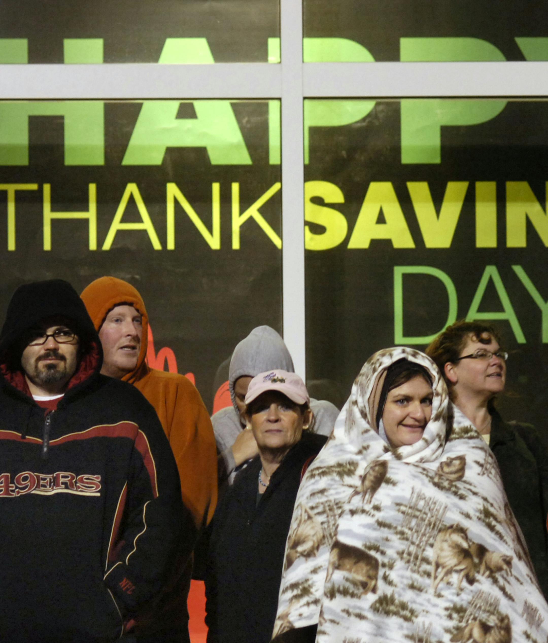 Bundled against the cold, shoppers hoping to get a jump on Black Friday watch others join the line Thanksgiving night, Nov. 24, 2011, in anticipation of the midnight opening at the Kohl's store in Marion, Ind. (AP Photo/The Marion Chronicle-Tribune, Jeff Morehead)