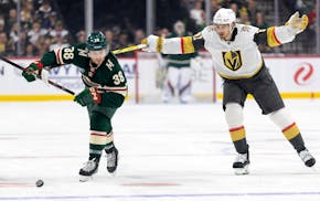 Brett Howden (21) of the Vegas Golden Knights gets his stick under the arm of Ryan Hartman (38) of the Wild on Saturday at Xcel Energy Center.
