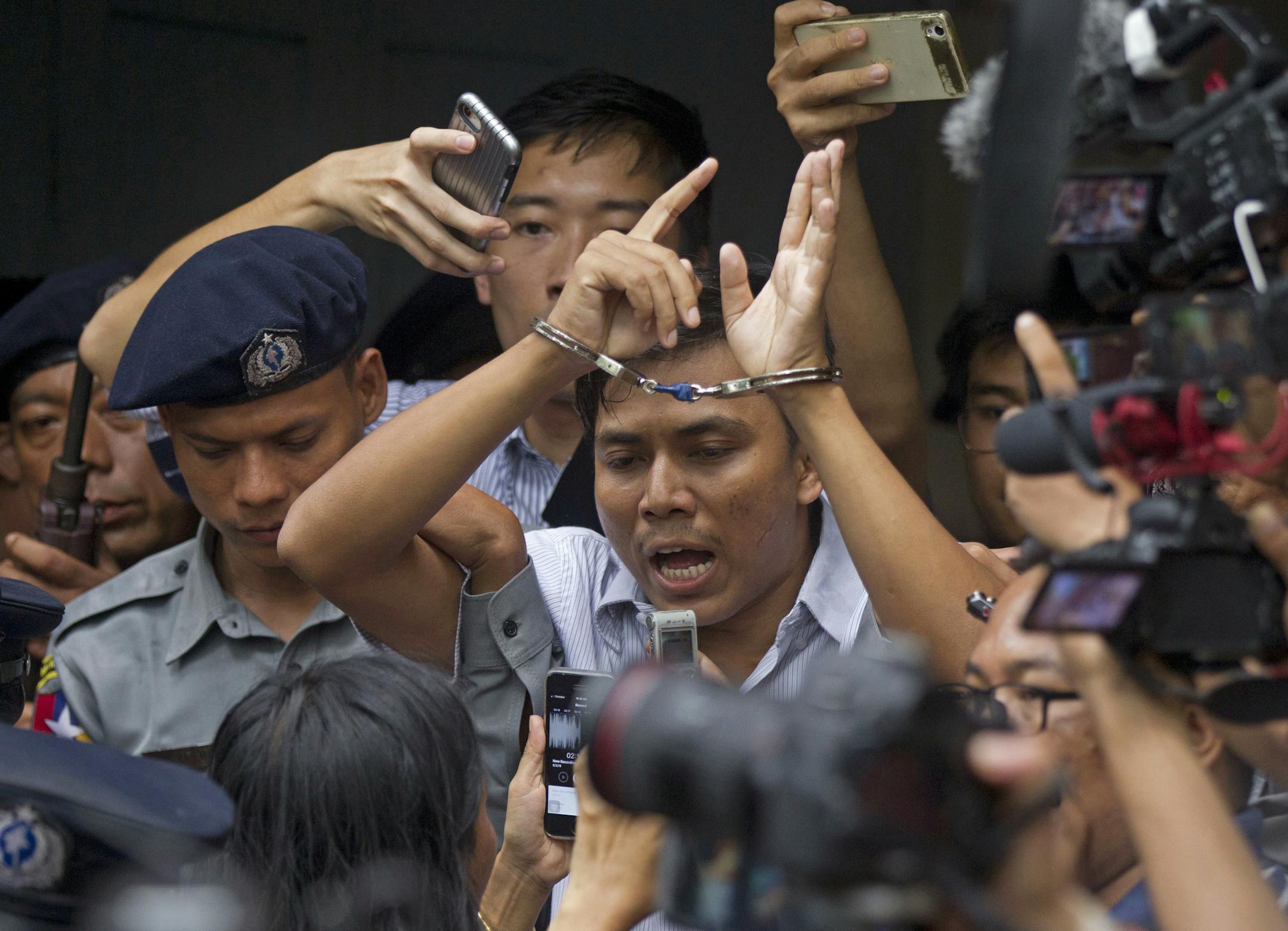 Reuters journalist Kyaw Soe Oo, center, talks to journalists during he is escorted by police as he leaves the court Monday, Sept. 3, 2018, in Yangon, Myanmar. A Myanmar court sentenced two Reuters journalists, Wa Lone and Kyaw Soe Oo, to seven years in prison Monday for illegal possession of official documents, a ruling that comes as international criticism mounts over the military's alleged human rights abuses against Rohingya Muslims. (AP Photo/Thein Zaw) ORG XMIT: XTZ110