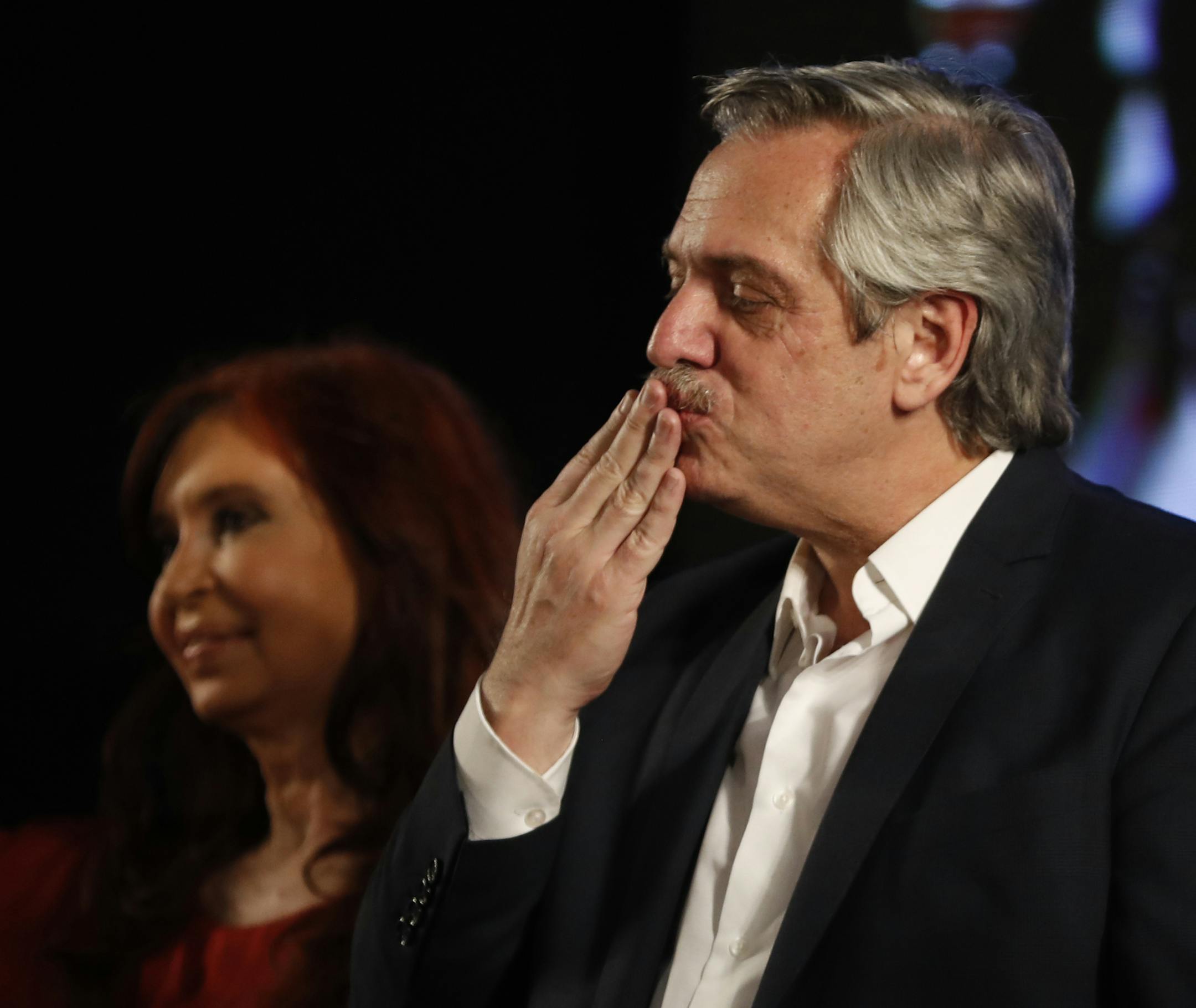 Peronist presidential candidate Alberto Fernández blows a kiss to supporters after incumbent President Mauricio Macri conceded defeat at the end of election day in Buenos Aires, Argentina, Sunday, Oct. 27, 2019. Behind is running mate, former President Cristina Fernández. (AP Photo/Natacha Pisarenko)