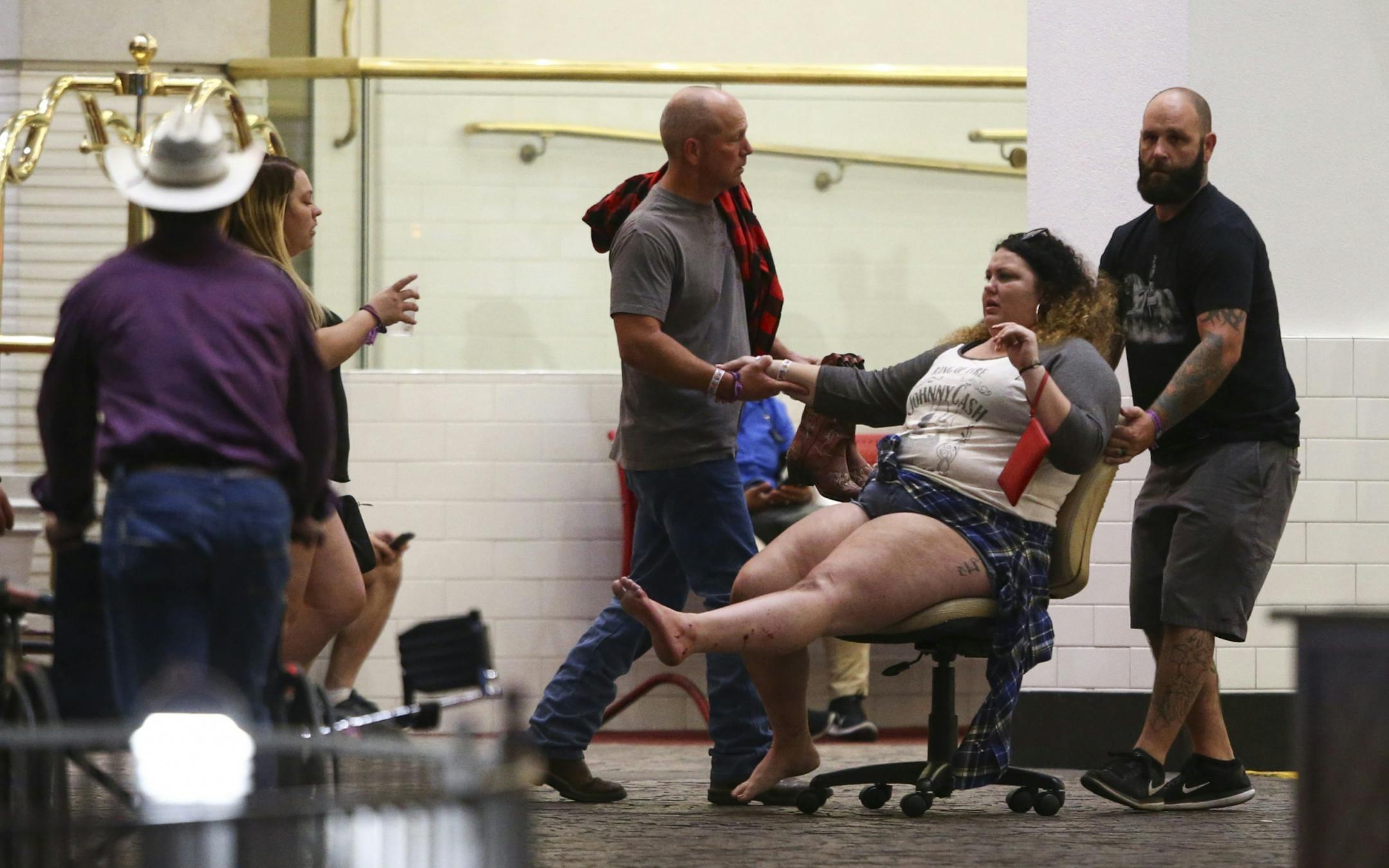 A wounded woman is moved outside the Tropicana during an active shooter situation on the Las Vegas Strip in Las Vegas Sunday, Oct. 1, 2017. Multiple victims were being transported to hospitals after a shooting late Sunday at a music festival on the Las Vegas Strip.