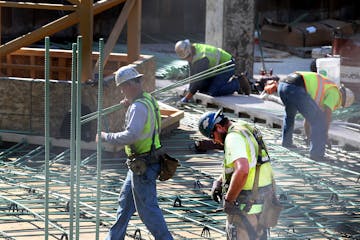 Iron workers on the job in downtown Minneapolis. The Workers’ Compensation Reinsurance Association is giving out a record distribution this year.