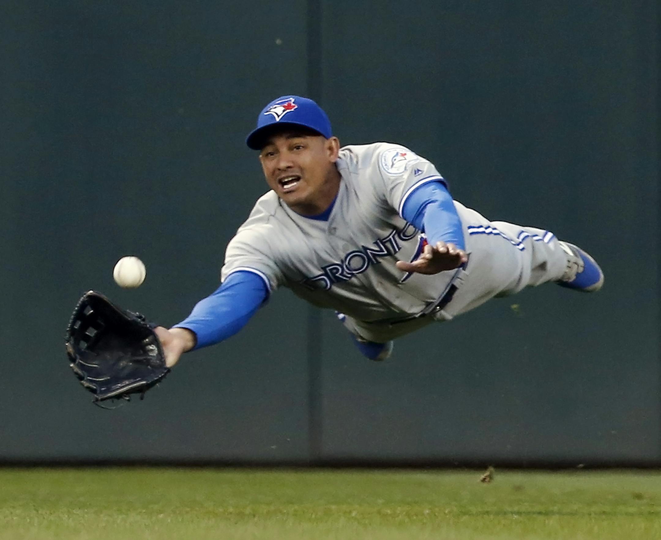 Toronto Blue Jays center fielder Ezequiel Carrera makes a diving catch to rob Minnesota Twins' Trevor Plouffe of a hit in the fourth inning of a baseball game Friday, May 20, 2016, in Minneapolis. (AP Photo/Jim Mone)
