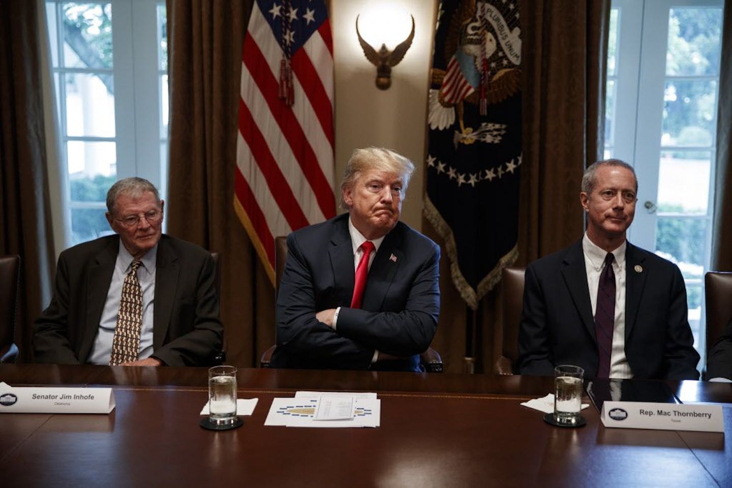 President Donald Trump pauses during a meeting with Republican members of Congress on immigration in the Cabinet Room of the White House, Wednesday, June 20, 2018, in Washington. From left, Sen. Jim Inhofe, R-Okla., Trump, and Rep. Mac Thornberry, R-Texas.