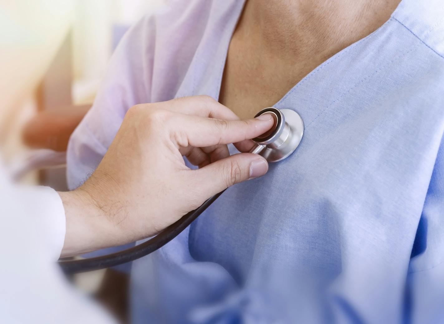 healthy concept; Doctor checking patient's heart with stethoscope at a hospital