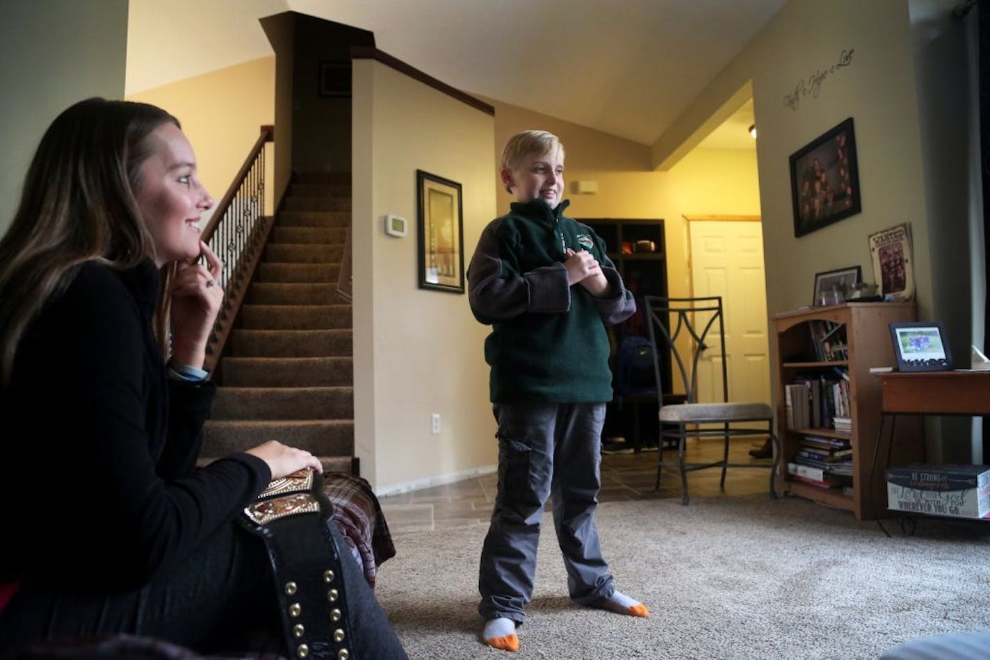 Eleven-year-old Gavin Pierson of Ramsey, MN, has been fighting Joe Bully since he was 5. That's what he has named his rare brain tumor, a growing mature teratoma, because of the way it breaks the rules and has threatened his life. Here, Pierson, a sixth grader, who has had 27 surgeries, is also a brown belt in karate and contemplates demonstrating a kick as his mom Nicole Pierson sat nearby in the family home Friday, Oct. 28, 2017, in Ramsey, MN.