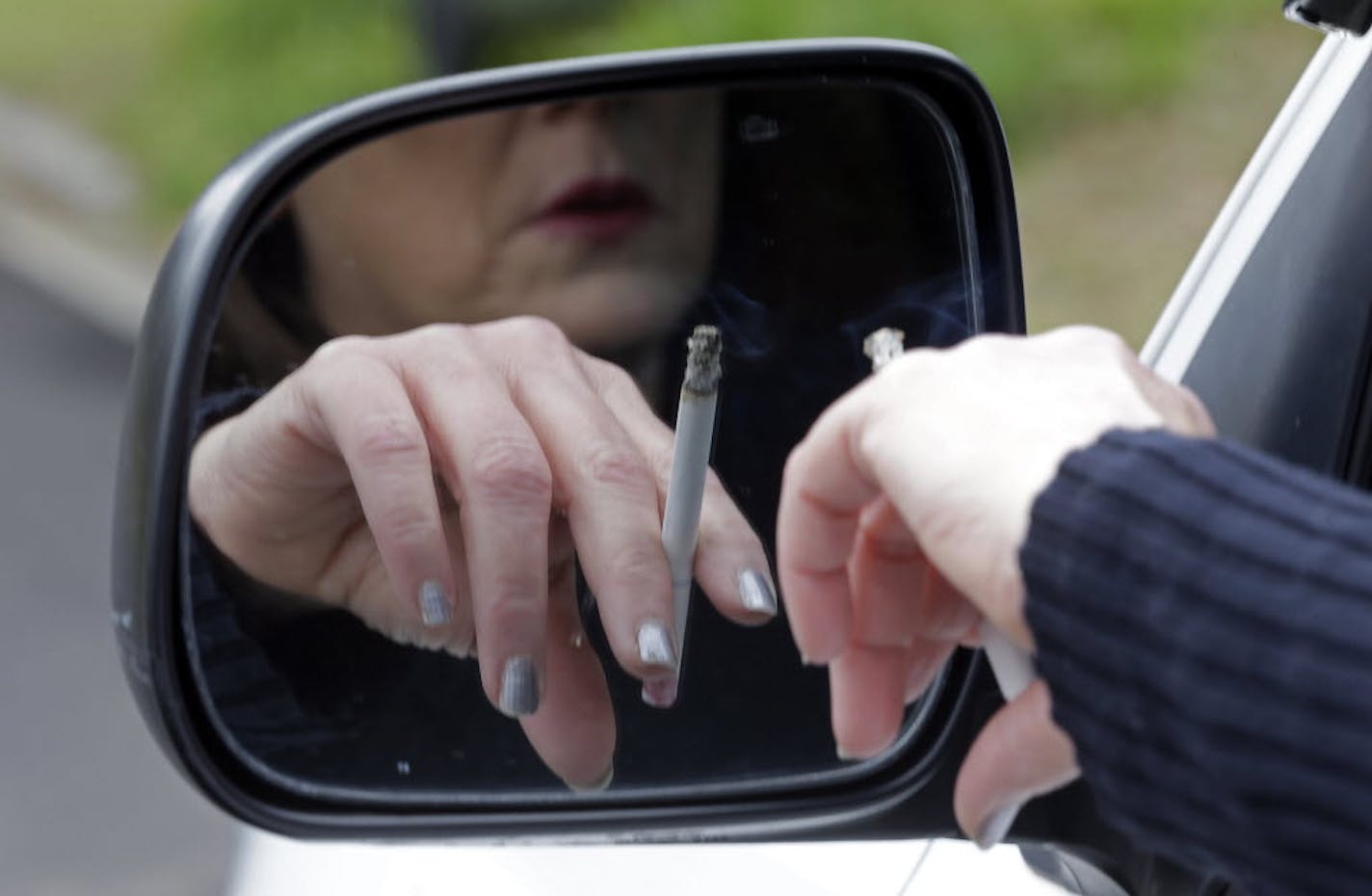 A woman smokes a cigarette while sitting in her truck in Hayneville, Ala.