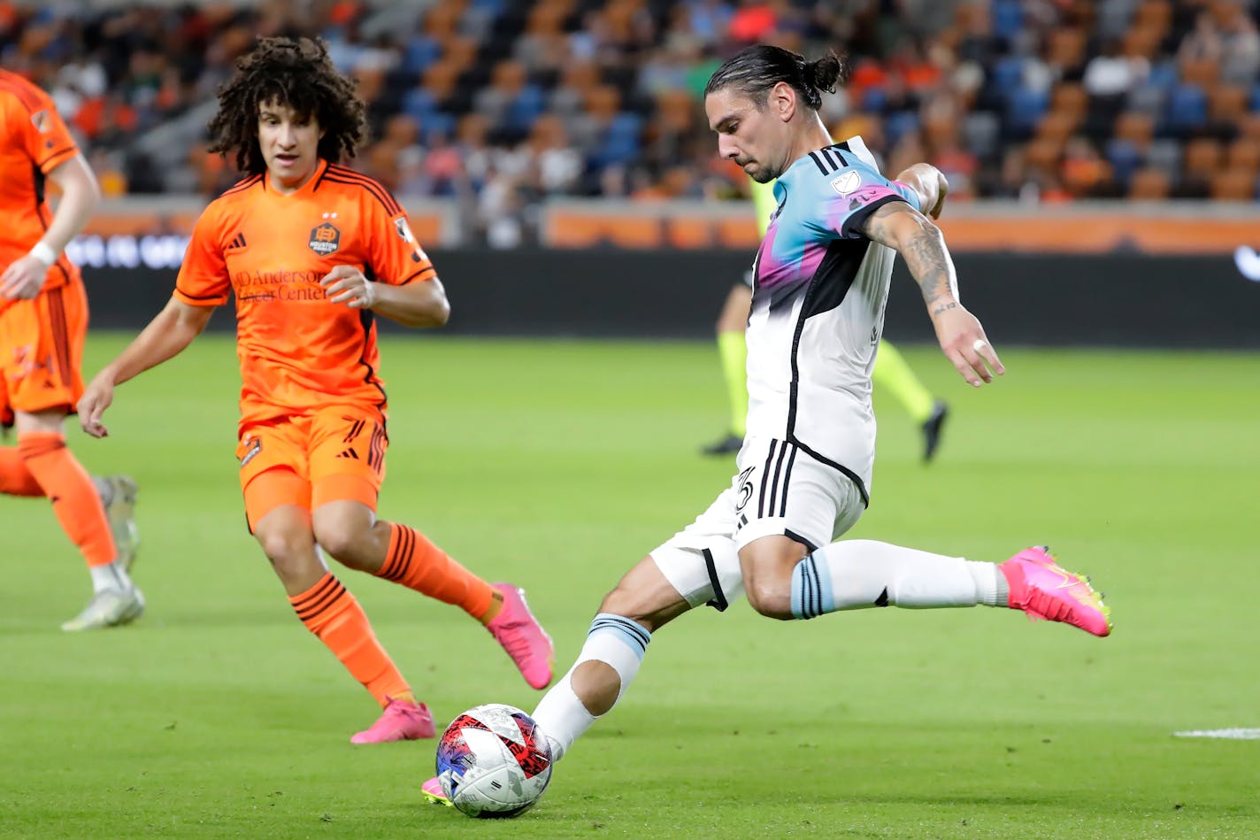 Minnesota United defender Zarek Valentin, right, kicks away in front of Houston Dynamo forward Ivan Franco, left, during the second half of an MLS soccer match Wednesday, July 12, 2023, in Houston. (AP Photo/Michael Wyke)