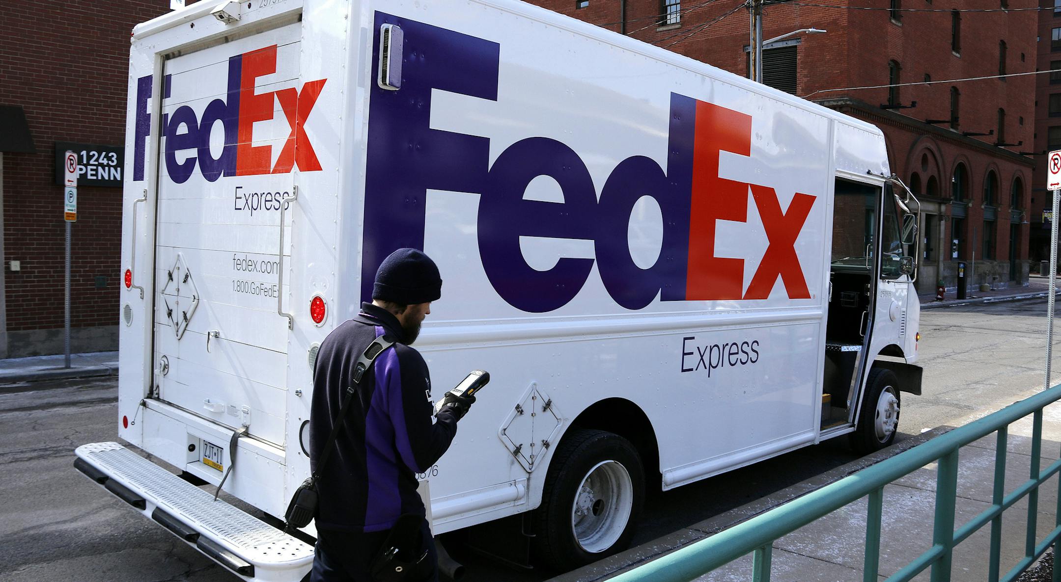 In this Friday, March 17, 2017, photo, a FedEx driver returns to his truck in downtown Pittsburgh. FedEx Corp. reports earnings Tuesday, Dec. 19, 2017. (AP Photo/Gene J. Puskar)