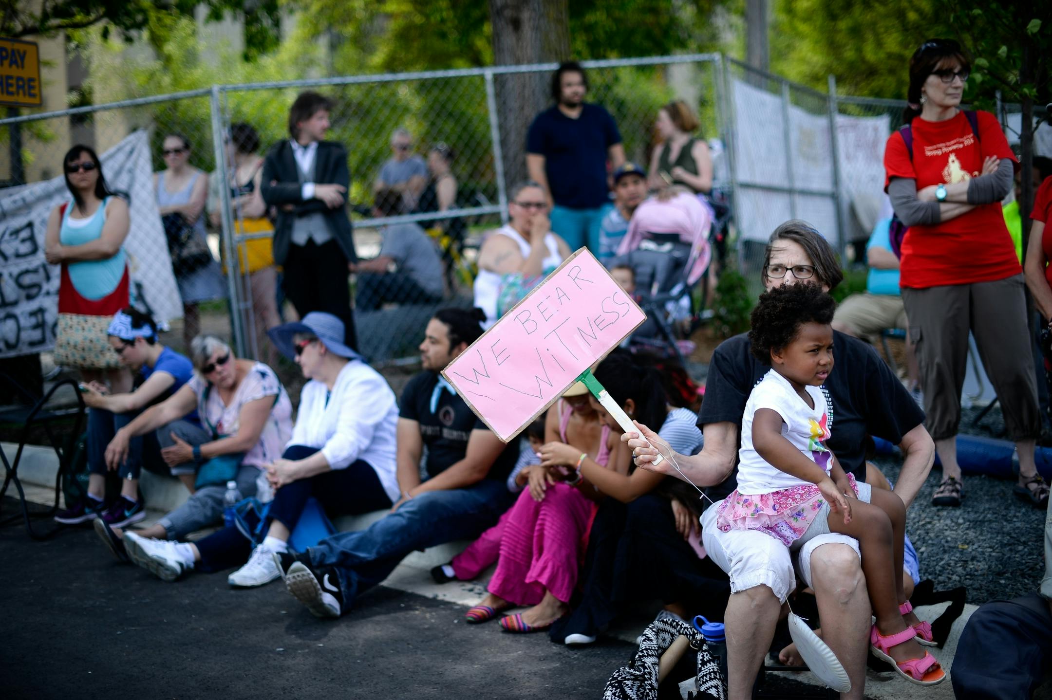 Isabella Jacobs, 4, sat on her mother Julie Jacob's lab as they waited for Friday's dismantling of the "Scaffold" sculpture to begin.
