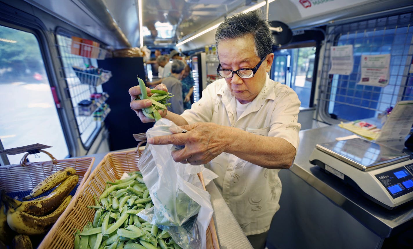 Tutian Tian bagged snap peas as he shopped on The Wilder mobile market bus Tuesday July 14, 2015 in St Paul, MN. ] Jerry Holt/ Jerry.Holt@Startribune.com ORG XMIT: MIN1507141625460256