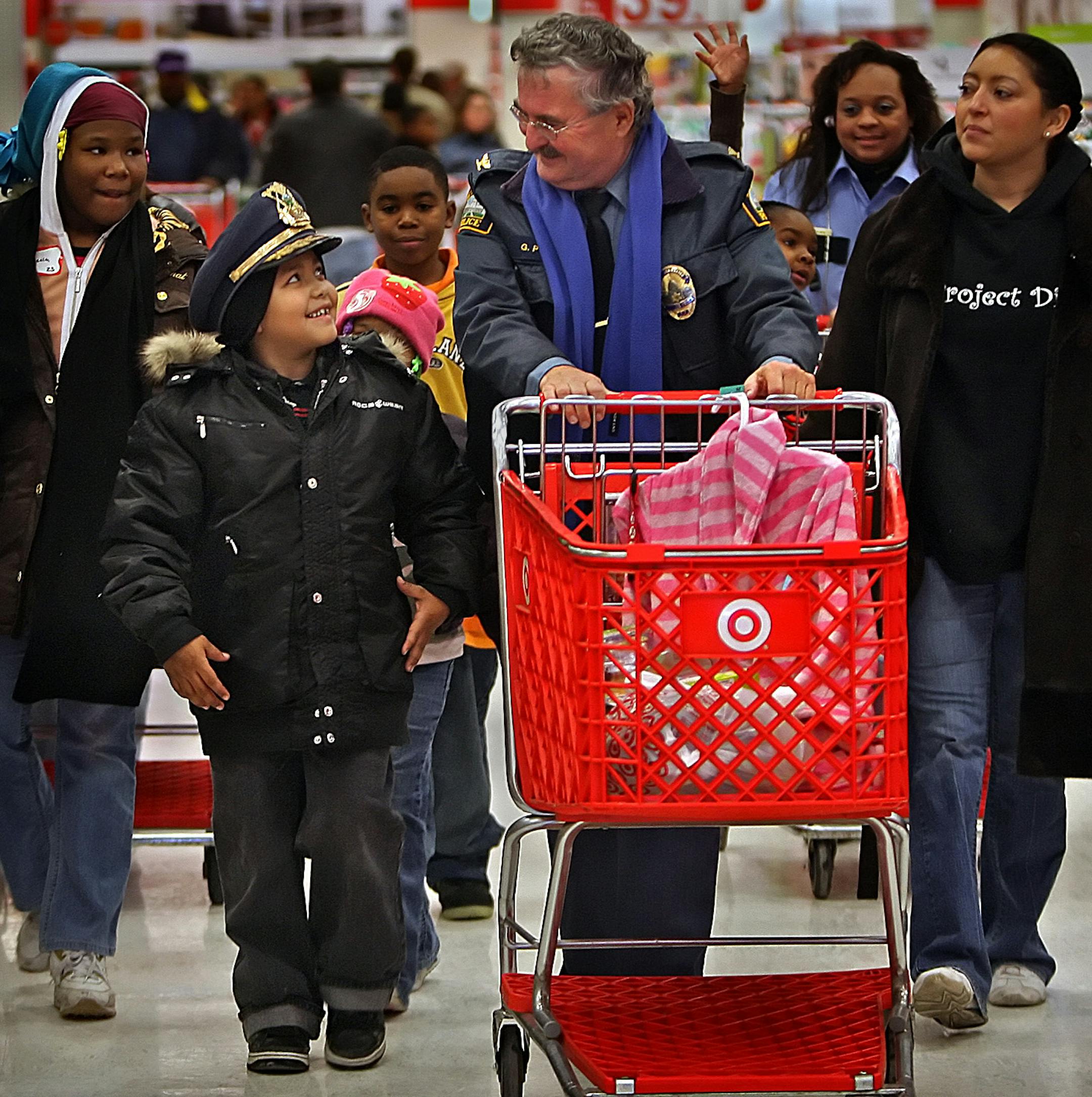 Mauricio Martin, 8, looked like he had found his new BFF in St. Paul Police senior commander Greg Pye, as they shopped Saturday. With them were, at left, Deonecia Crockett, 10, and volunteer Johanna Olson, right.