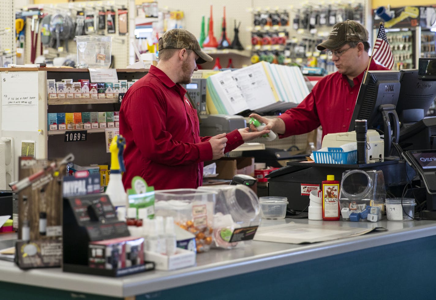 Bob Swanson gave fellow cashier Micah Avery a squirt of hand sanitizer at Buck's Hardware in Grand Marais on Friday afternoon.