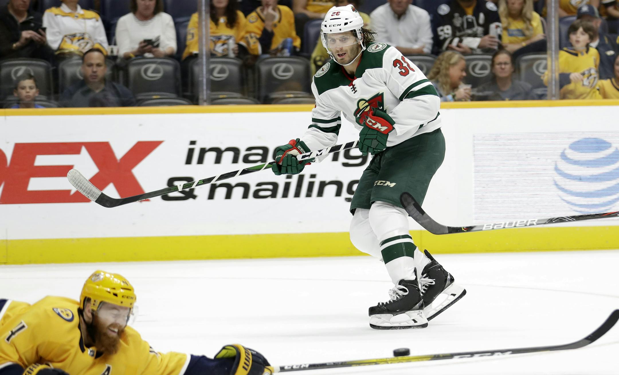 Nashville Predators defenseman Ryan Ellis (4) reaches to block a pass by Minnesota Wild right wing Ryan Hartman (38) during the first period of an NHL hockey game Thursday, Oct. 3, 2019, in Nashville, Tenn. (AP Photo/Mark Humphrey)
