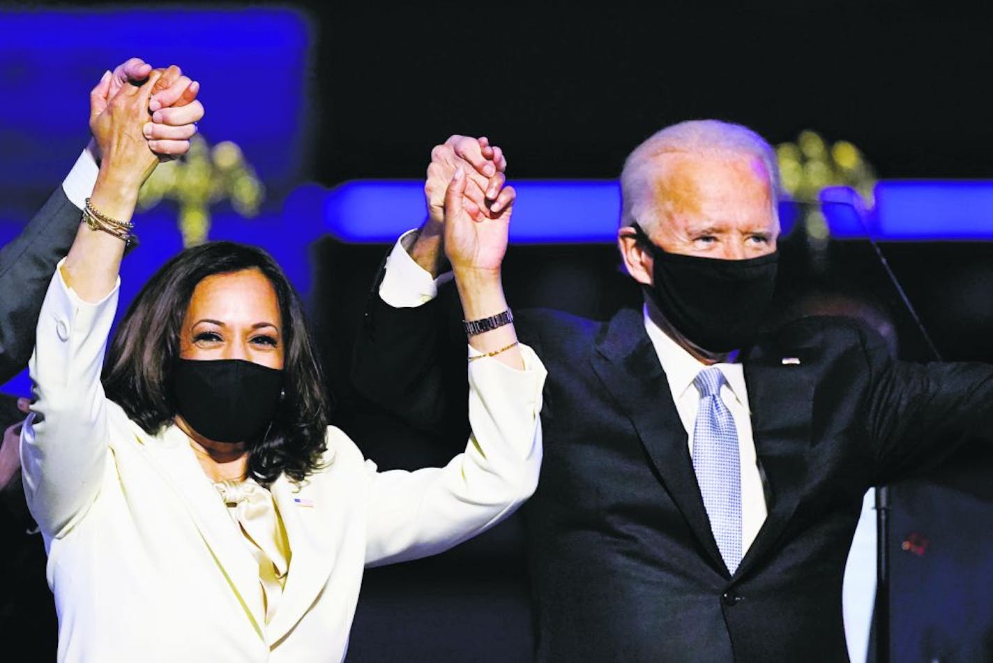 Vice President-elect Kamala Harris held hands with President-elect Joe Biden and her husband, Doug Emhoff, as they celebrated Saturday, Nov. 7, 2020, in Wilmington, Del.