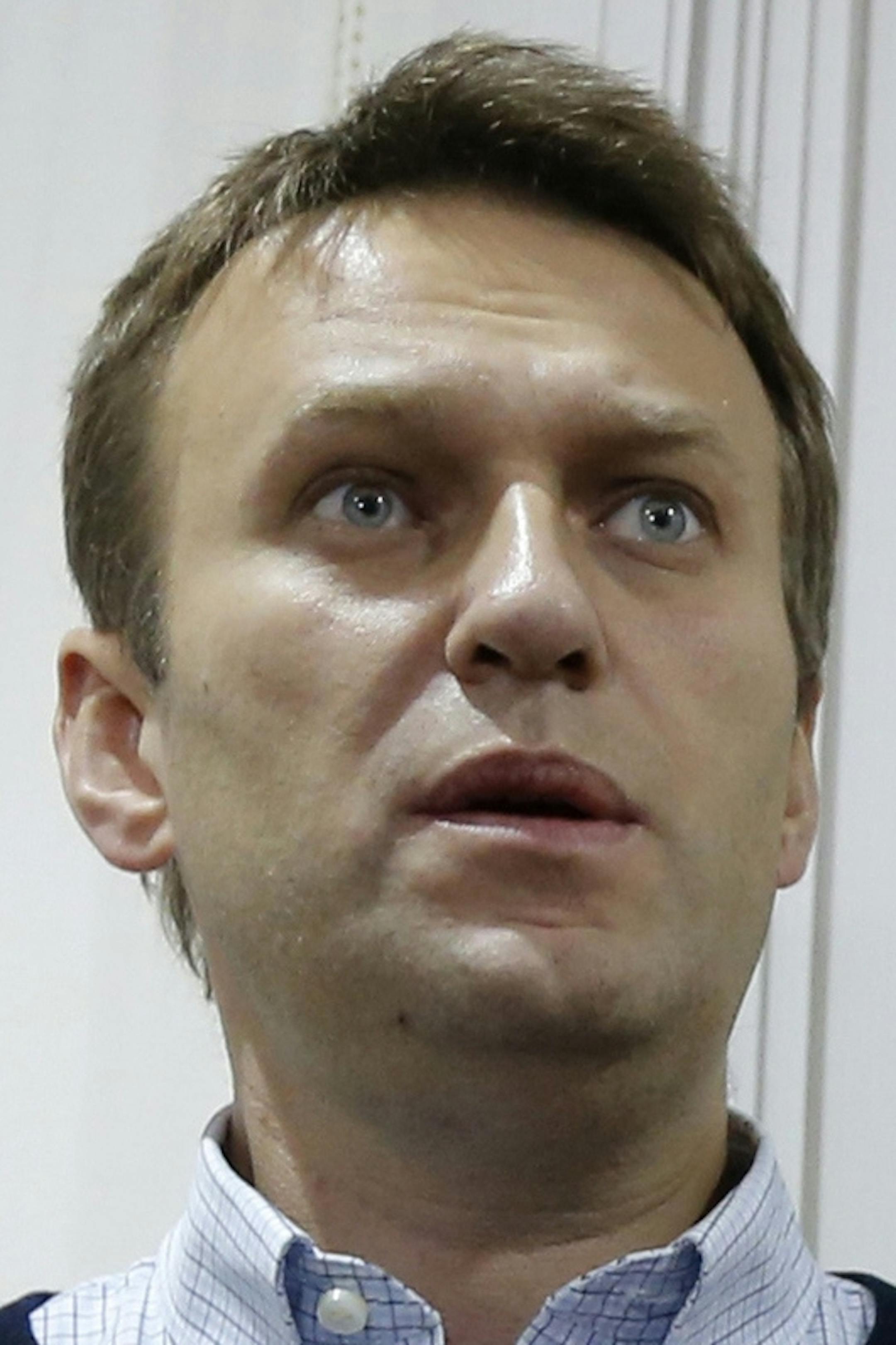 Russian opposition leader Alexei Navalny with his wife Yulia visits the exhibition "Drawing a trial" in Kirov, Russia, Wednesday, Oct. 16, 2013. A Russian court decided on Wednesday not to send Alexei Navalny to prison, a move that could have sparked major protests and made a martyr out of the charismatic 37-year-old opposition leader. (AP Photo/Dmitry Lovetsky)
