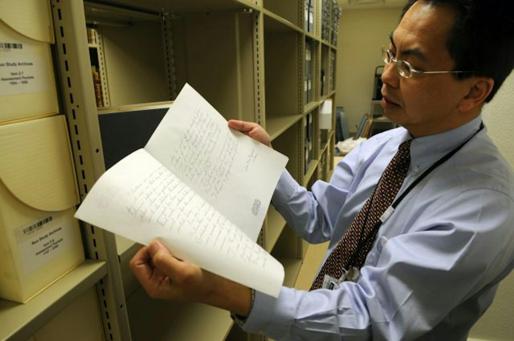 Dr. Kelvin Lim, the study's new lead scientist, held an essay written by one of the nuns who took part. That archive material is "a gold mine," Lim said.