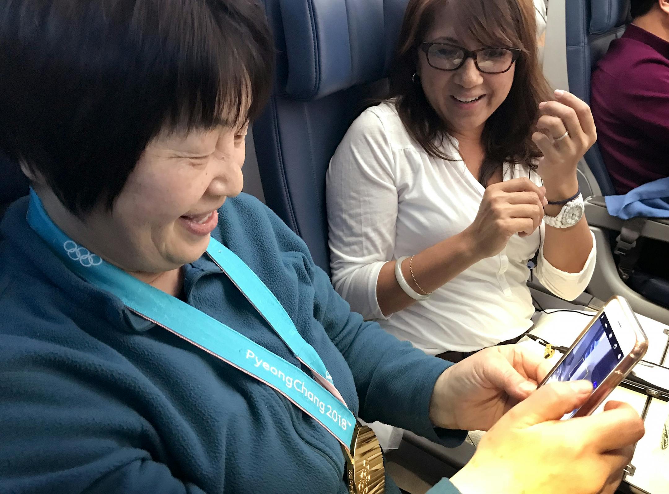 Passengers took photos with John Shuster gold medal on the flight home from South Korea.
