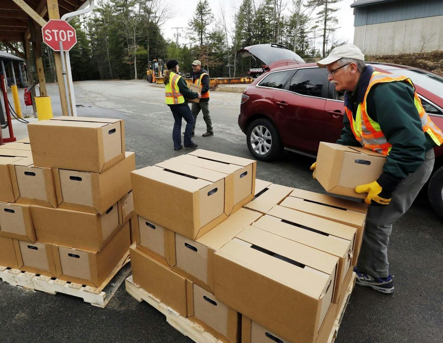 FILE - In this Monday, April 11, 2016 file photo, New Hampshire state and local officials load boxes of free bottled water in in Litchfield, N.H. New Hampshire is suing eight companies including 3M and Dupont for damage it says has been caused statewide by a class of potentially toxic chemicals found in everything from pizza boxes to fast-food wrappers. The state becomes the second in the nation to go after the makers of perfluoroalkyl and polyfluoroalkyl substances or PFAS and the first to targ