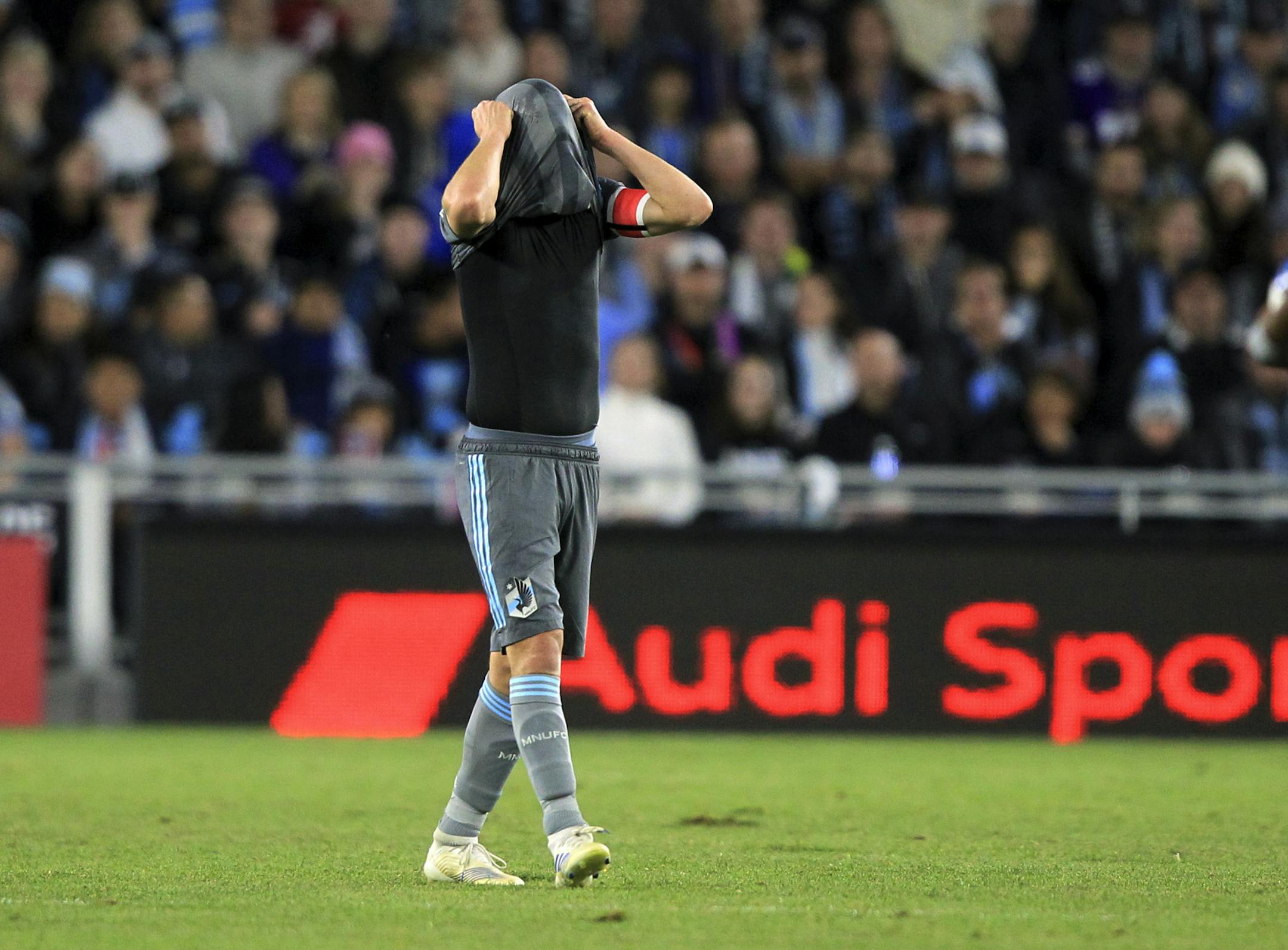 Minnesota United's Osvaldo Alonso covers his head with his jersey after the LA Galaxy scored a goal in the second half of an MLS first-round playoff soccer match, Sunday, Oct. 20, 2019, in St. Paul, Minn. The Galaxy won 2-1. (AP Photo/Andy Clayton-King)