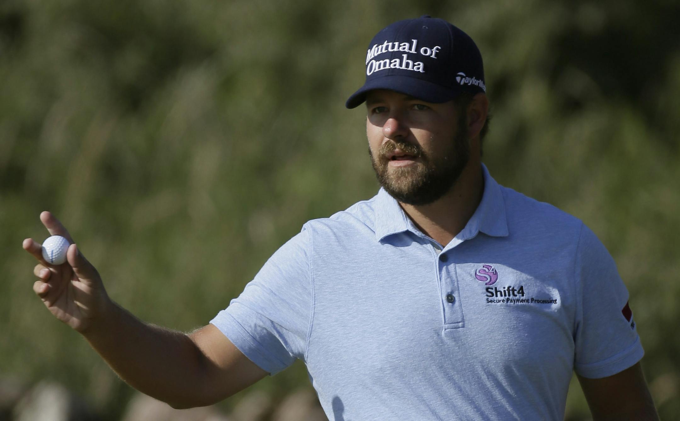 Ryan Moore of the United States holds up his ball after putting on the second green during the second round of the British Open Golf Championship at Muirfield, Scotland, Friday July 19, 2013. (AP Photo/Jon Super)