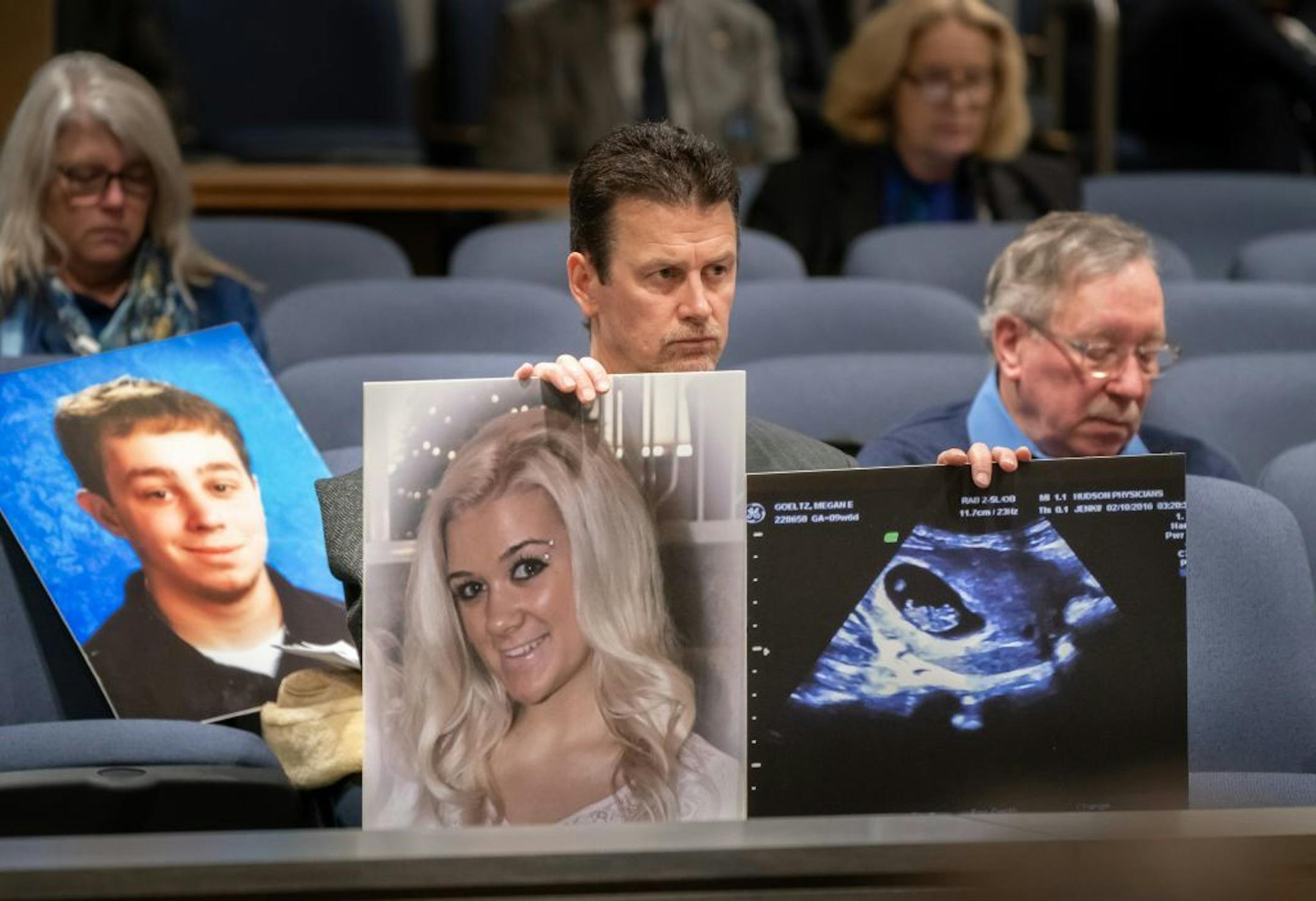 Tom Goeltz held a photo of his daughter daughter Megan, who was struck and killed by a driver who police say might have been distracted by his phone. She was pregnant at the time, and Goeltz held a photo of her unborn baby. On the right is John Dudley whose son Andrew was killed while on his bicycle by a distracted driver in 2012. Andrew's photo is on the left.