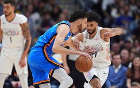 Thunder forward Chet Holmgren, left, drives past Nuggets guard Jamal Murray in the first half of Thursday night's Game 6 of their Western Conference s