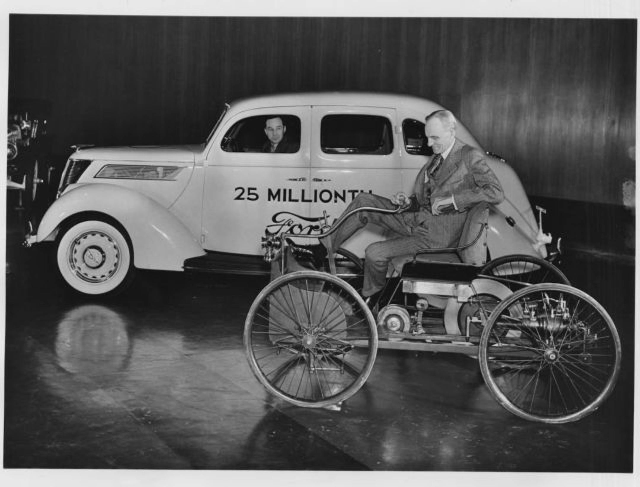 Edsel Ford, then-president of the Ford Motor Company, poses with the 25,000,000th Ford passenger car, a V-8, in this January 1937 file photo. Henry Ford is seated in his first car, built in 1896.