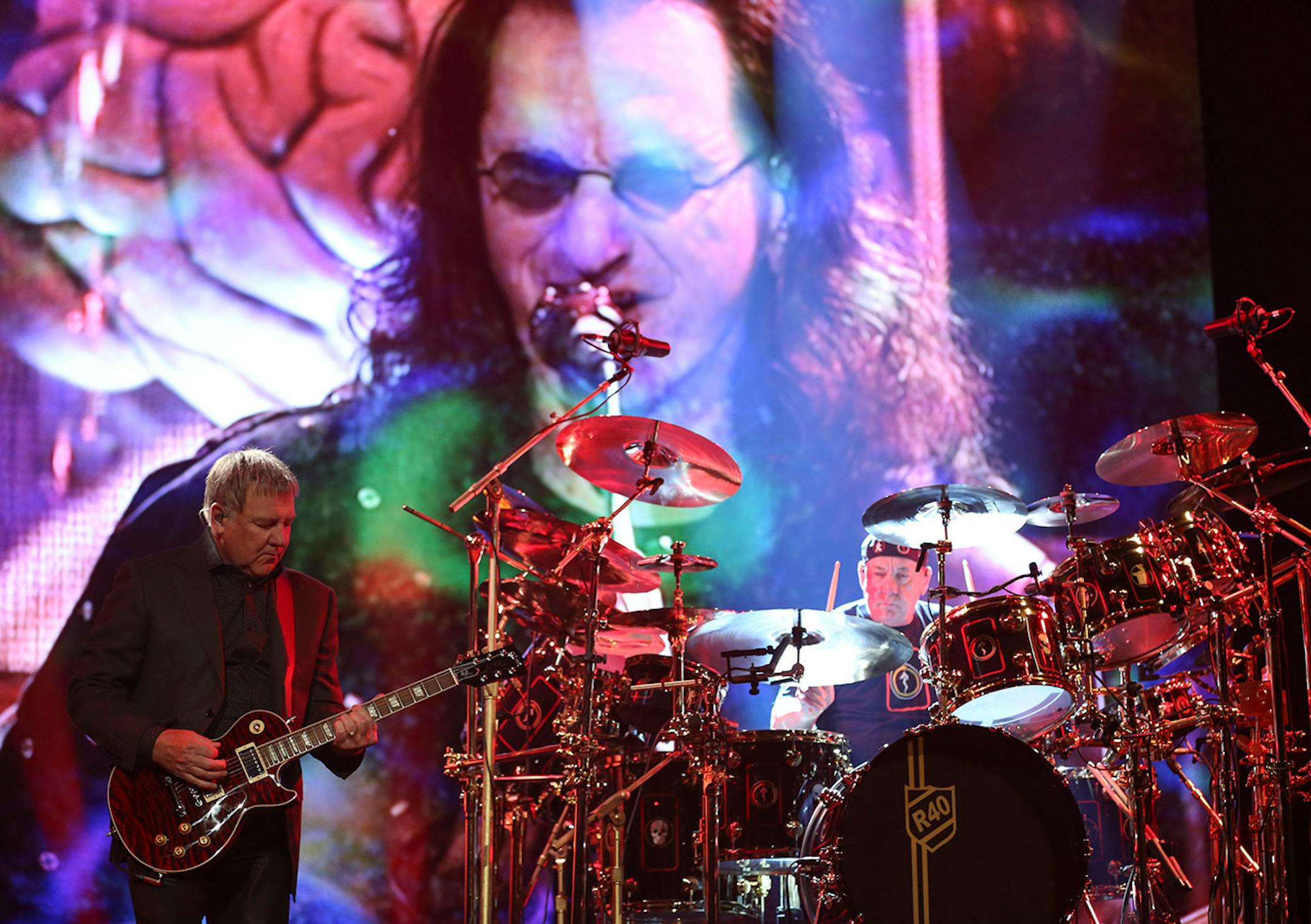 Rush guitarist Alex Lifeson and drummer Neil Peart played in front of their bandmate, Geddy Lee, as he was projected on the screen behind them in a May 2015 concert at Xcel Energy Center in St. Paul.