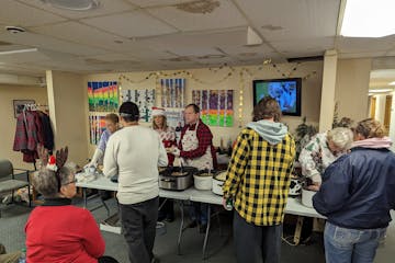 A board member for the Nameless Coalition for the Homeless in Bemidji and other volunteers serve a Christmas meal to clients earlier this month.