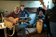 Ivan Fontanez (Banjo), at left, plays guitar while practicing with band members of Lightening and Thunder in a basement studio in Minneapolis.
