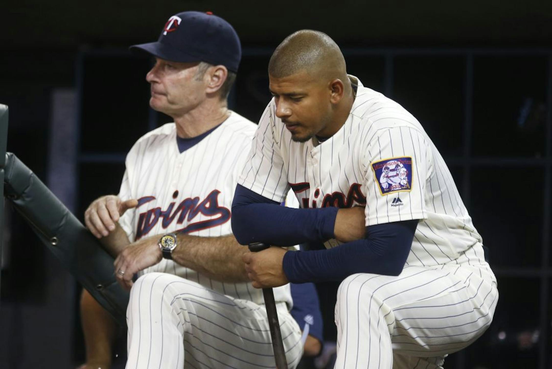 Minnesota Twins' Eduardo Escobar, waits to bat, next to manager Paul Molitor during the ninth inning of the second game of a doubleheader Aug. 11